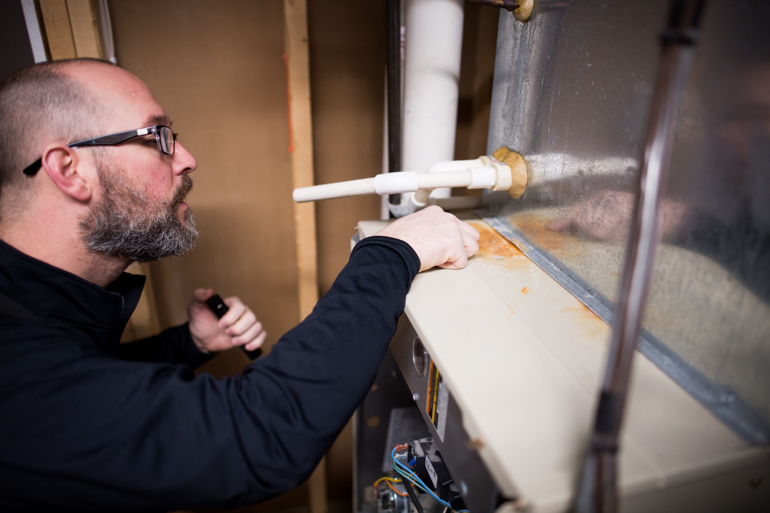 Home inspector examining exterior and structural features during wind mitigation inspection