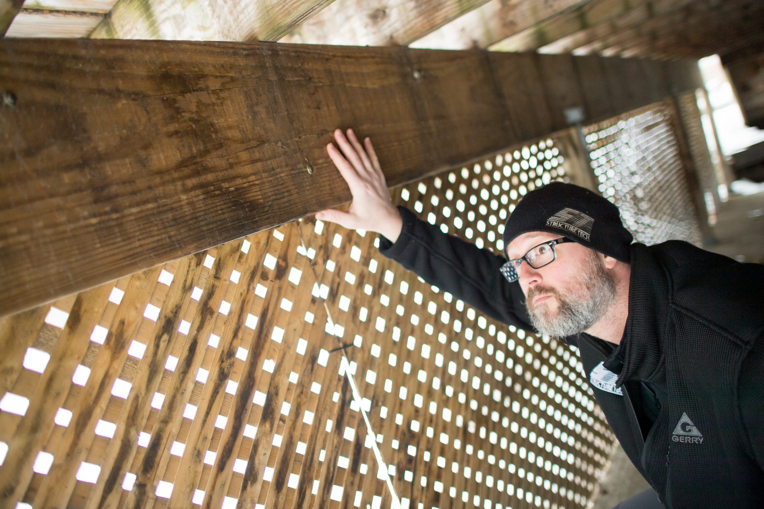 Home inspector examining structural systems for termite and wood-destroying organism damage
